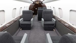 Private jet interior with grey seats and dark veneer