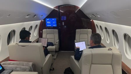 Interior of private jet with passengers using laptops