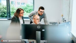 Three colleagues collaborating around computer