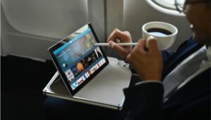 Person using tablet with stylus on aircraft