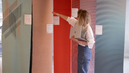 Woman examining hanging material samples on display
