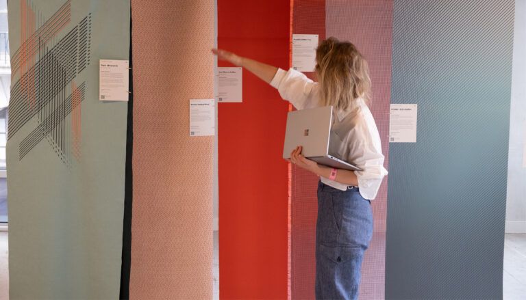 Woman examining hanging material samples on display