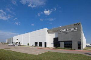 Modern Gulfstream facility exterior with white walls and blue sky