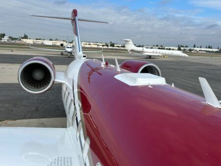 Red and white private jet on airport tarmac