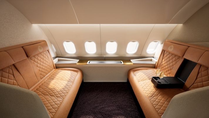 Luxury aircraft cabin with quilted tan leather seats and windows