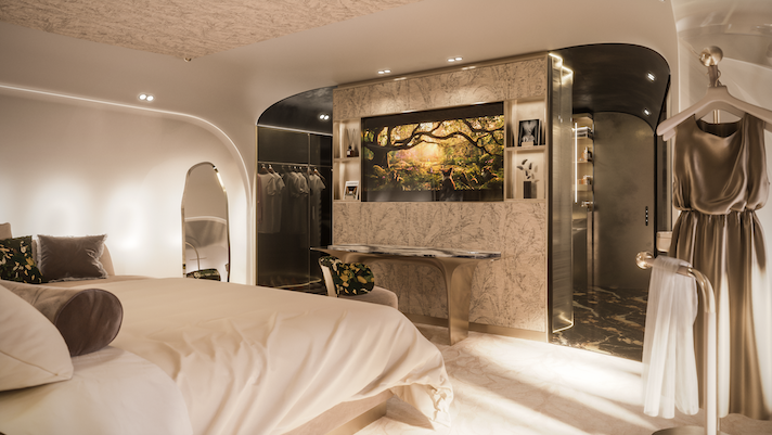 private jet bedroom with TV screen on central unit 