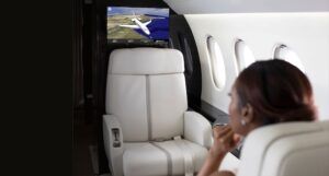 Passenger viewing flight map on screen in luxury jet