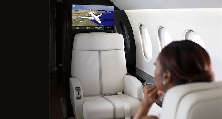 Passenger viewing flight map on screen in luxury jet