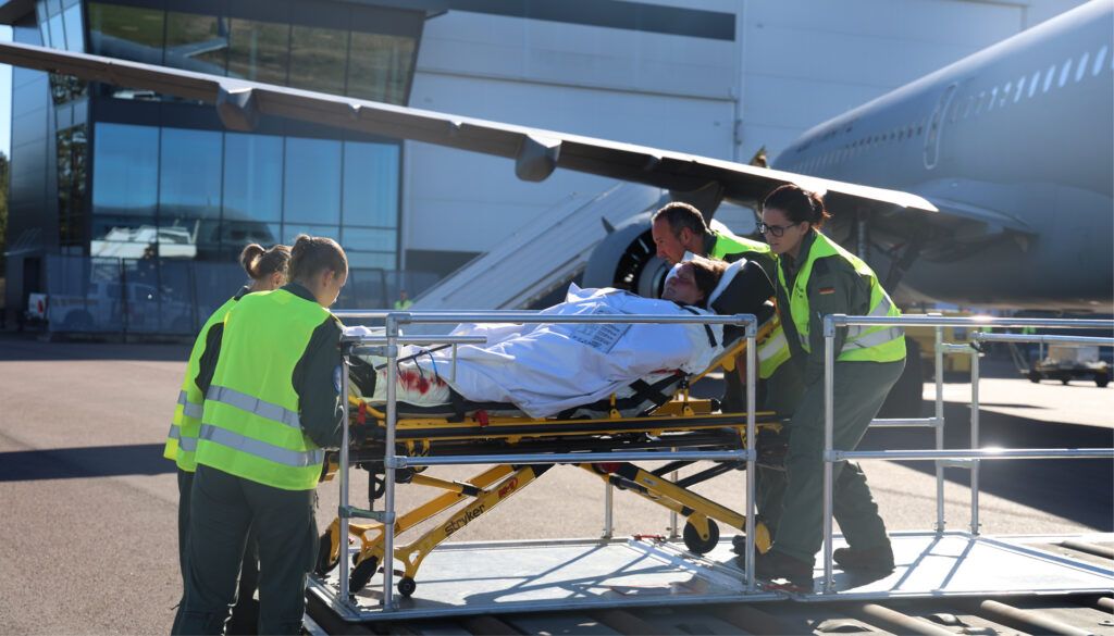 Medical staff loading patient on stretcher into aircraft