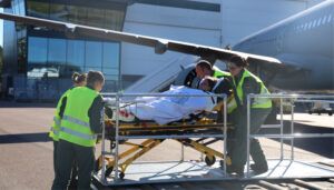 Medical staff loading patient on stretcher into aircraft