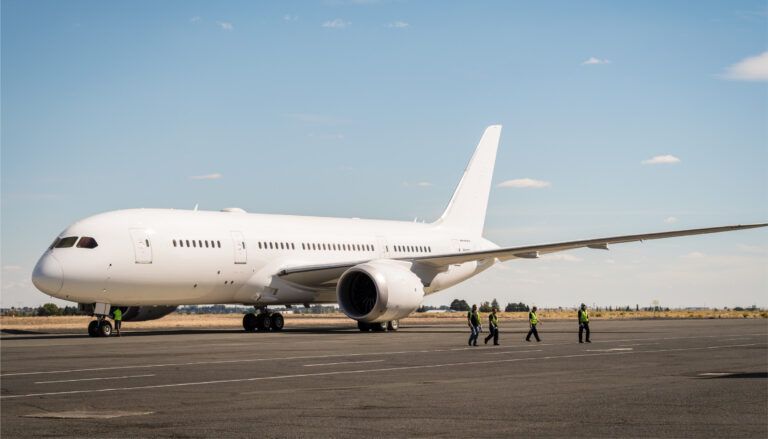 BBJ 787 refurbished at Greenpoint Technologies Ground crew walking past white Boeing 787 on tarmac