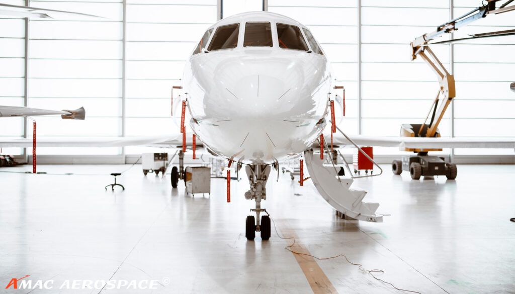 White business jet in bright hangar bay