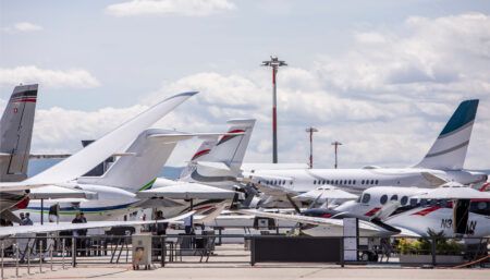 Multiple private jets parked on tarmac at aviation event