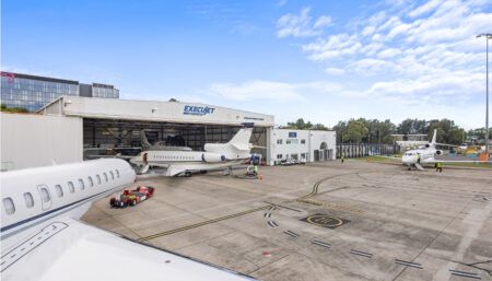 Hangar facility with multiple business jets on tarmac