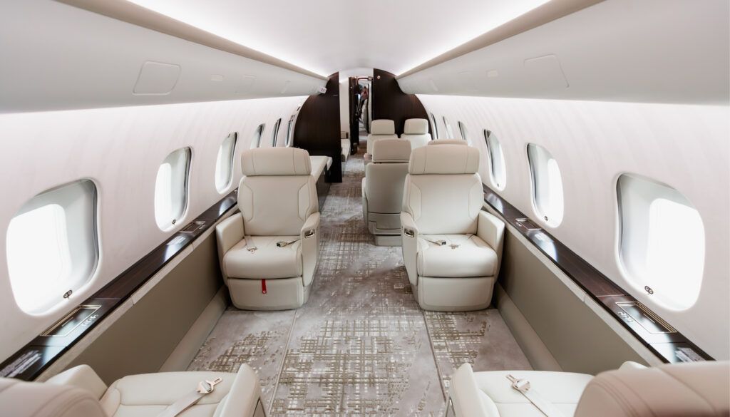 Business jet cabin with cream leather seats and carpet
