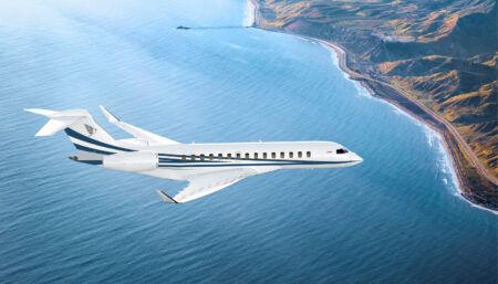 Business jet in Comlux livery flying over coast