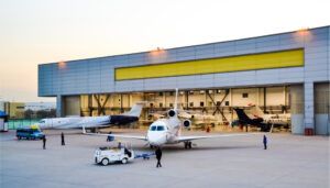 Multiple business jets outside maintenance hangar