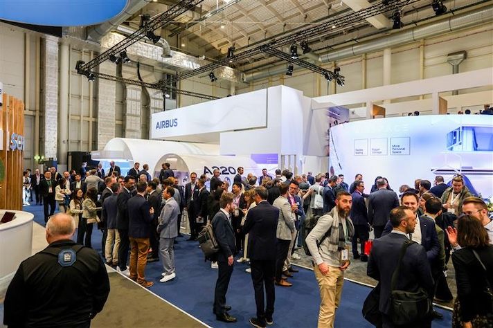 Crowded Airbus exhibition booth at aviation trade show with attendees