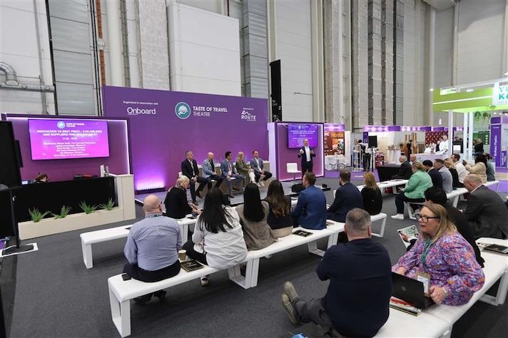 Panel discussion at travel conference with audience seated on benches