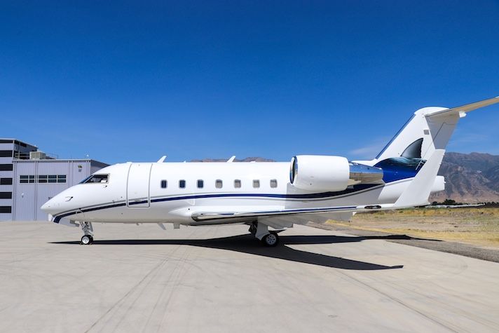 White and blue business jet parked on airport tarmac