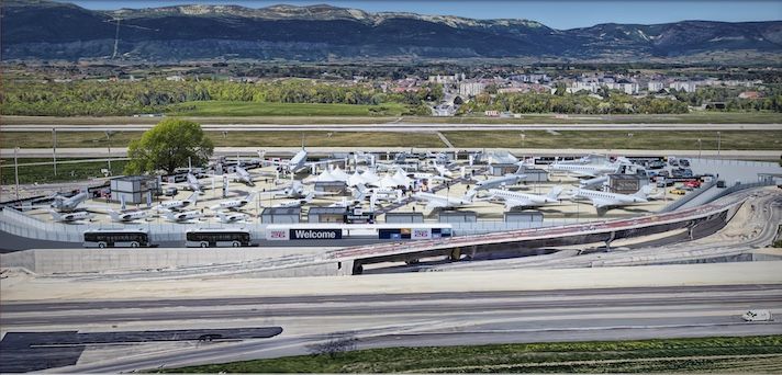 Aircraft static display area at airshow with mountain backdrop