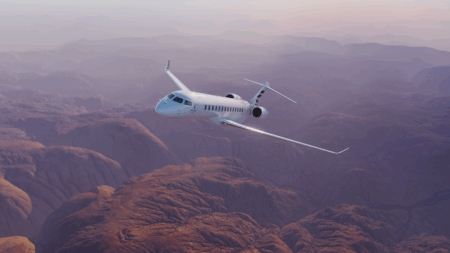 Global 8000 awarded Transport Canada type certification White private jet flying over dramatic desert canyon landscape at dusk with purple and pink sky