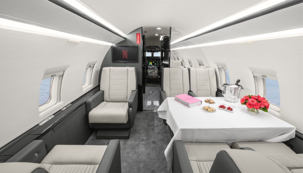 Challenger 604 cabin with dining table and leather seats