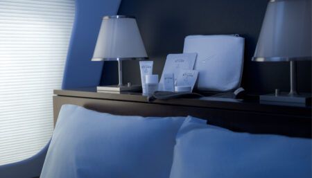 Luxury amenity kit on shelf next to bed on private jet