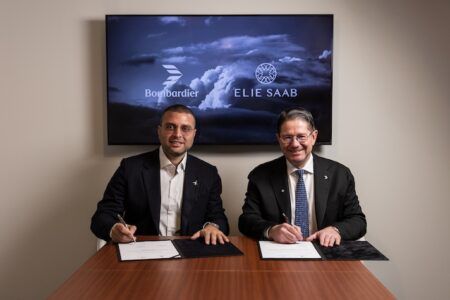 Elie Saab Junior and Éric Martel signing agreement beneath Bombardier and Elie Saab logos