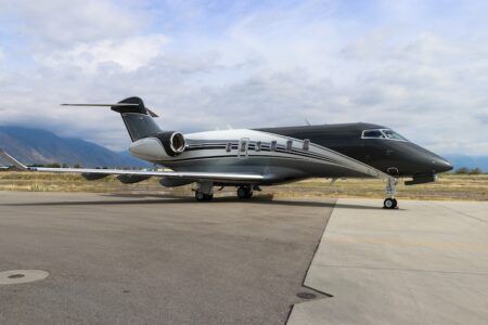 Duncan Aviation completes CL-350 refurbishment Black private jet parked on tarmac near mountains