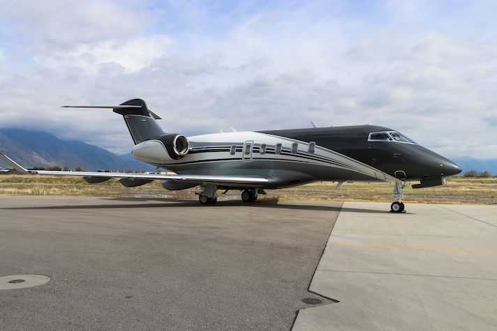 Duncan Aviation completes CL-350 refurbishment Black private jet parked on tarmac near mountains