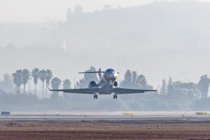 Business jet landing on runway at dawn