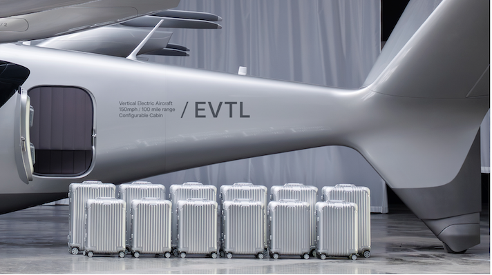 Silver suitcases lined up beside EVTL aircraft fuselage