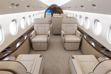 VIDEO: Falcon 900EX refurbishment by Duncan Aviation Falcon 900EX business jet cabin interior showing cream leather seats with diamond quilting, brown wood veneer siderails and beige carpet