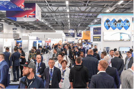 Farnborough International Airshow 2026 adds sixth hall Busy exhibition hall at Farnborough International Airshow showing crowded aisles with international exhibitor stands and visitors in business attire