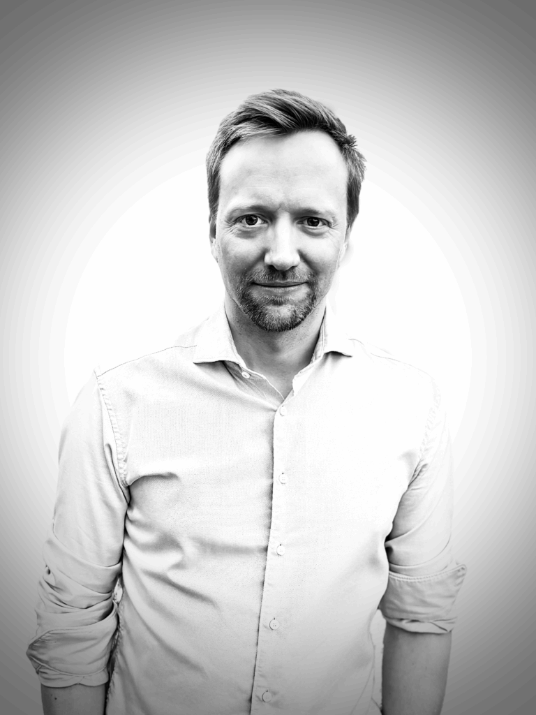 Black and white portrait photograph of David von Holt against plain background