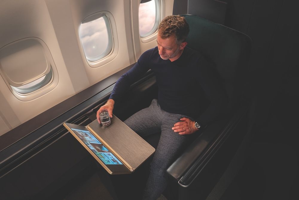 Overhead view of man seated on aircraft with nice intellitable showing digital content