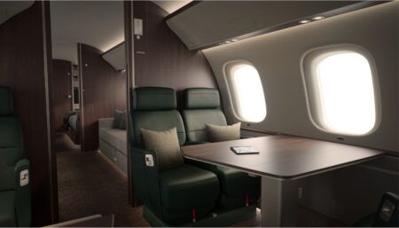 Private jet interior with green leather seats and table