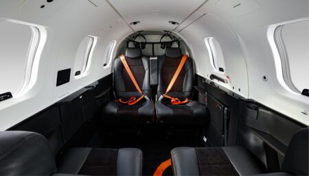 TBM 980 unveiled with enhanced avionics and cabin TBM 980 aircraft interior with black seats and orange seatbelts