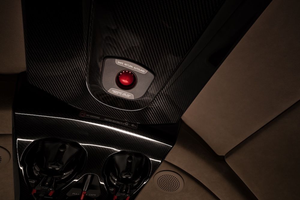 Cirrus G3 Vision Jet overhead panel showing red Safe Return Autoland system activation button with carbon fibre surround
