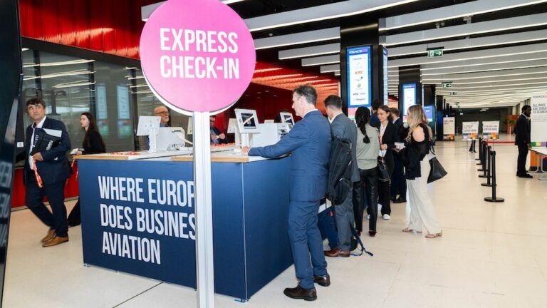 Ticket sales open for EBACE26 Business aviation professionals queue at an express check-in desk at EBACE, with signage reading “Where Europe Does Business Aviation” on the counter front.