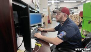 James Johnson working at a computer workstation on the production facility floor