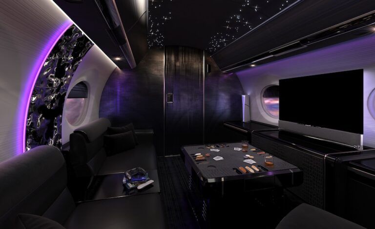 DESIGN BRIEF: Sigma Nera by Alicja Kotlarek Rendering of a dramatic private jet lounge with deep purple ambient lighting illuminating an abstract wall panel, a fibre optic star-effect ceiling, dark ribbed panelling on bulkheads, a low central table set with playing cards, tokens and whisky glasses, black soft seating, and a large flatscreen pop-up monitor atop cabinet on right wall.
