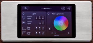 Alto Aviation Cadence CMS touchscreen control panel with brushed metal surround, displaying a lighting control screen with wash lights colour wheel on a dark interface.