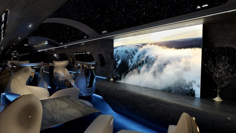 A dramatic widebody cabin concept interior (Maverick) with a starfield ceiling, large LED wall display and curved seating.