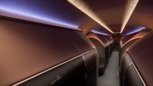 Rendering of The Bow VIP cabin interior showing a row of closed private Bow Suites with warm copper-toned mood lighting and a central aisle.