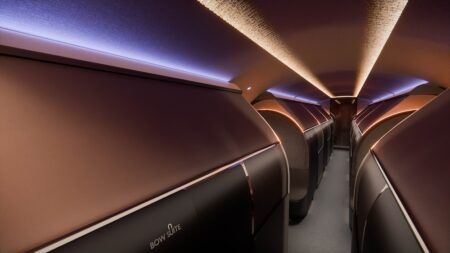 Rendering of The Bow VIP cabin interior showing a row of closed private Bow Suites with warm copper-toned mood lighting and a central aisle.