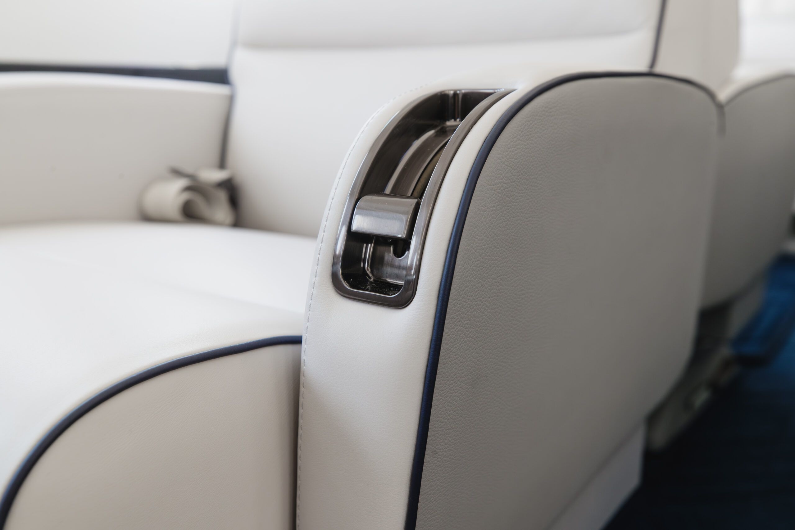 Galley area of the refurbished Falcon 2000EXy with marble worktop, dark glossy wood veneer cabinetry, glassware storage and view through to the cockpit