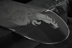 Close-up photograph of a stainless steel panel featuring an intricately etched dragon motif.