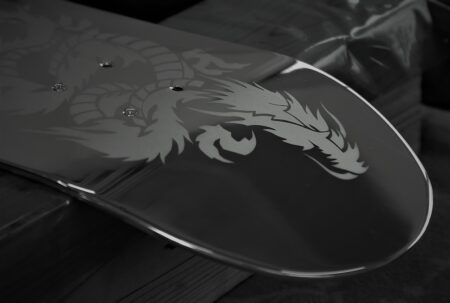 Close-up photograph of a stainless steel panel featuring an intricately etched dragon motif.